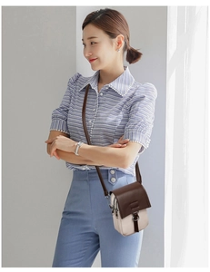 Close-up of a two-tone leather crossbody phone bag on a model in natural light