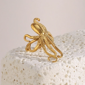 Vue détaillée d'une bague pieuvre dorée à texture granuleuse sur pierre blanche
