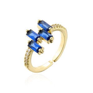 Macro detail of three blue emerald-cut zircons set on a gold plated open ring