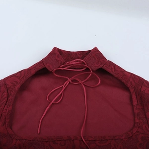 Detalle del top de encaje burdeos con diseño calado y cierre de cordones en el cuello