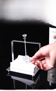 Vertical stainless steel napkin holder featuring a crystal-topped weighted arm in use