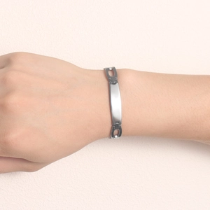 Polished silver stainless steel bracelet with sleek rectangular plaque on wrist