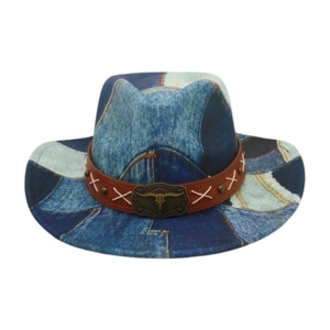 Detail of western cowboy hat featuring denim patchwork and a bull skull metal buckle