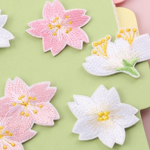 Pink and white cherry blossom embroidery patches displayed on fresh green background