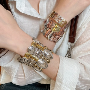 Detail of vintage layered stretch bracelet featuring heart charms and dream love engravings
