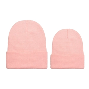 Close-up of pink matching parent-child knit beanies with ribbed texture and folded cuffs
