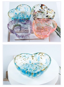 Macro shot of heart-shaped resin bowls with colorful crystal stones and gold foil flakes