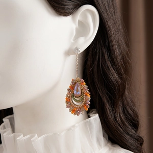 Vintage boho drop earrings with colorful bead weaving and teardrop opal stone on a model