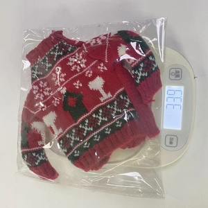 Detailed view of red knitted Christmas wine bottle cover with elk pattern on scale
