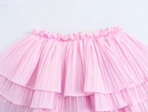 Detail of pink layered ruffle skirt featuring elastic waistband and pleated fabric texture