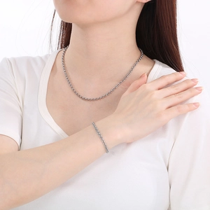 Detailed view of silver stainless steel double loop chain necklace and bracelet on model