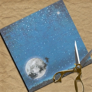 Macro shot of square Christmas scrapbook paper with Santa sleigh over blue starry sky