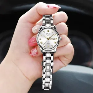 Detailed shot of silver quartz watch with white dial and day-date display held in hand