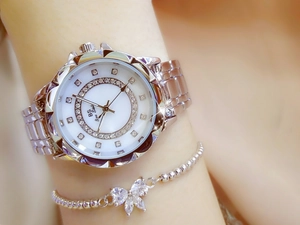 Detail of silver ladies watch with crystal bezel and matching floral charm bracelet