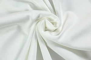 Close-up of white synthetic fabric showing soft pleated texture and knit detail