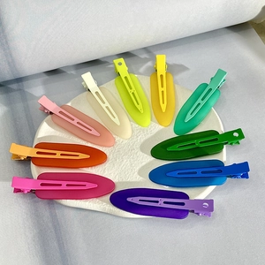 Detailed top view of ten colorful matte hair clips arranged on a white round plate