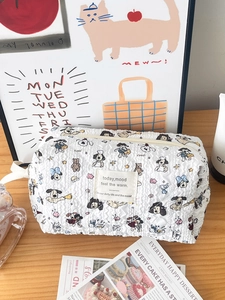 Detail of white quilted cosmetic bag with cute cartoon puppy print on a wooden desk
