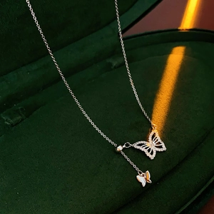 Macro detail of a silver butterfly pendant with micro-set crystals on green velvet