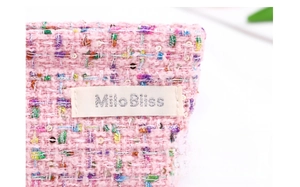 Detailed macro view of pink tweed cosmetic pouch with sequins and MiloBliss label