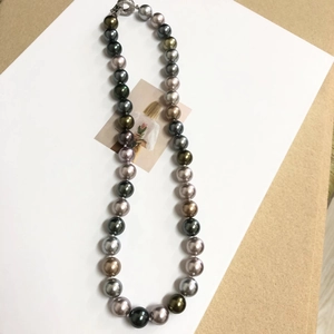 Detail of multi-color Tahitian pearls and sparkling metal clasp on jewelry card
