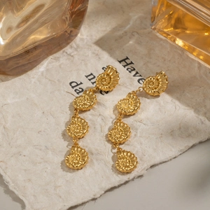 Elegant gold-plated shell tassel earrings displayed on a vintage paper background