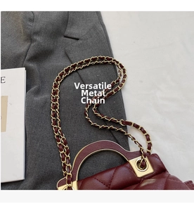 Detail of burgundy quilted leather handbag with gold chain strap and metal hardware