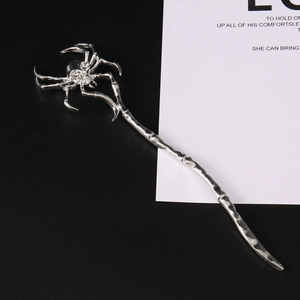 Macro detail of a silver metal spider hair stick with sparkling crystal embellishments