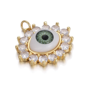 Macro shot of gold evil eye pendant with green enamel and white zircon stones
