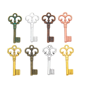 Set of 8 vintage style metal alloy key pendants in various colors on white background