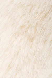 Macro texture of off-white faux fur fabric showing dense soft fibers and subtle glossy finish