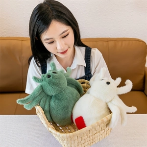 Soft green and white plush spider toys in a woven basket with a person in the background