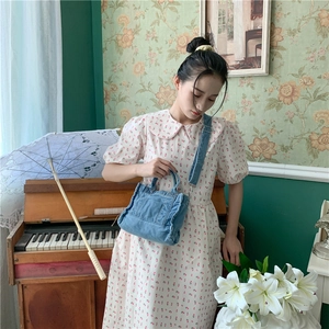 Vintage blue denim canvas shoulder bag styled in a retro floral room with a white dress