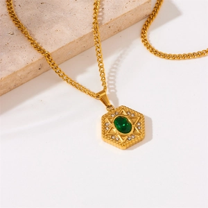 Detailed shot of hexagonal gold-plated pendant with green oval gem and star design
