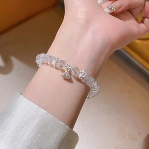 Détail d'un bracelet en cristal avec pendentifs lotus et cosse de lotus en argent
