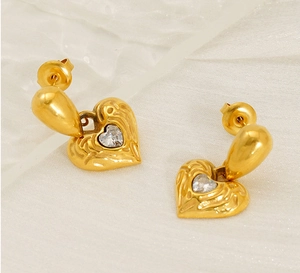 Detailed close-up of 18k gold heart earrings with sparkling center crystal