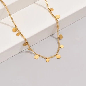 Minimalist gold clavicle necklace featuring multiple polished flat round disk pendants