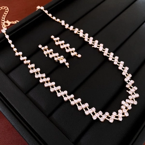 Close-up of gold-tone geometric square rhinestone necklace and earring set on black display