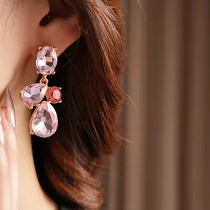 Vintage geometric water drop earrings with pink crystals and gold plating on a model