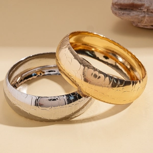 Golden and silver wide metal bangles with embossed crocodile texture and glossy finish