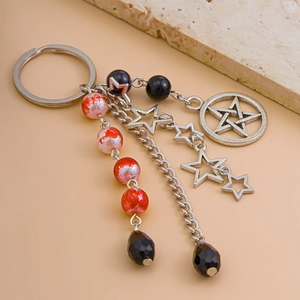 Detail of silver star pendants and marbled beads on a keychain with a tiered chain