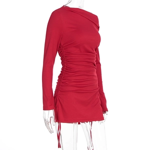Detail of red ribbed knit dress featuring side drawstring ruching and asymmetric collar