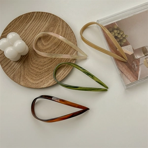 U-shaped acetate hair pins in white, beige, marble green, and tortoiseshell patterns