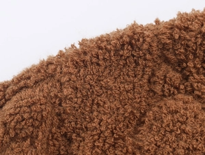 Texture macro del tessuto in pile marrone spesso su maglione cardigan invernale