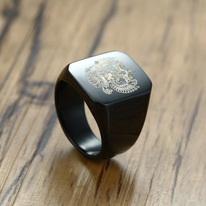 Macro detail of square black signet ring featuring a golden double-headed eagle emblem