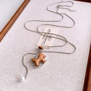 Silver snake chain necklace with wooden horse pendant and white pearl detail