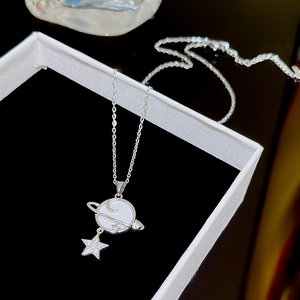 Macro shot of silver planet necklace with moon inlay and sparkling star pendant