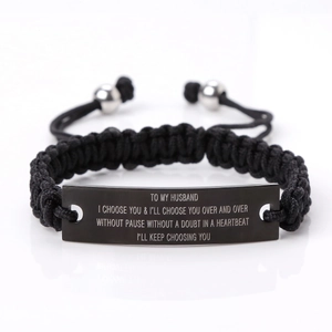 Detail of hand-woven black cord bracelet with engraved black stainless steel bar for men