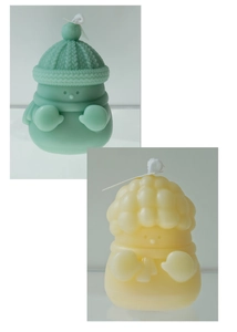 Dettaglio delle candele a forma di pupazzo di neve verde menta e crema con trama sciarpa