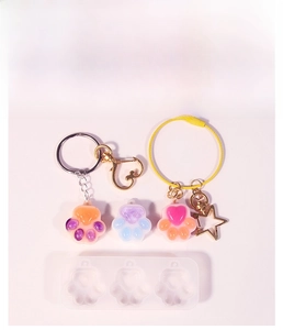 Detail view of cat paw resin molds with heart shakers and colorful finished pendants