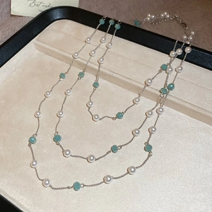 Dettaglio di collana argento a due strati con perle bianche e perle sfaccettate verde acqua